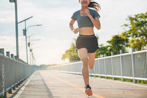 Young woman running in the nature. Healthy lifestyle and sport concepts.  Runner training in a urban area.The woman with runner on the street be running for exercise. © Sirichai