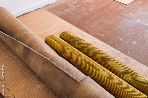 ripped up and rolled up carpet and floor underlay revealing floorboard in home interior renovation project, home improvement and DIY