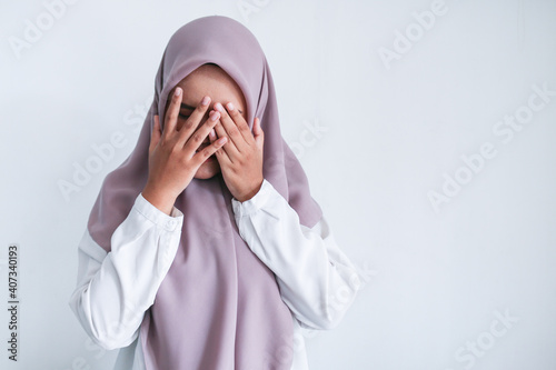 Young Asian Islam women wearing headscarf is covering her face with hand. Islam culture concept