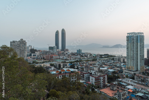 Xiamen city skyline with modern buildings, old town and sea at dusk photo