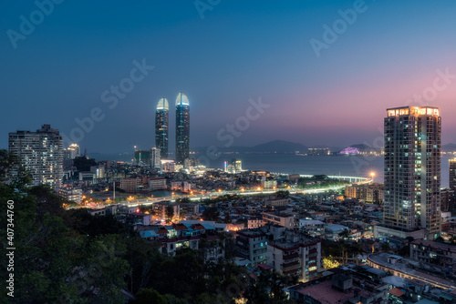 Xiamen city skyline with modern buildings  old town and sea at dusk