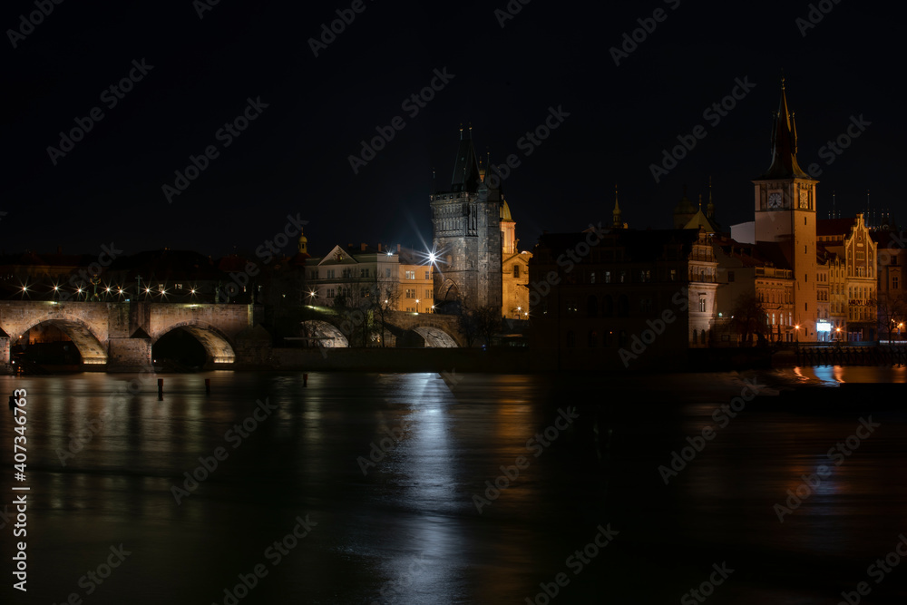 .panoramic view of Charles Bridge and illuminated street lights and the surrounding old architecture in the center of Prague in the Czech Republic at night