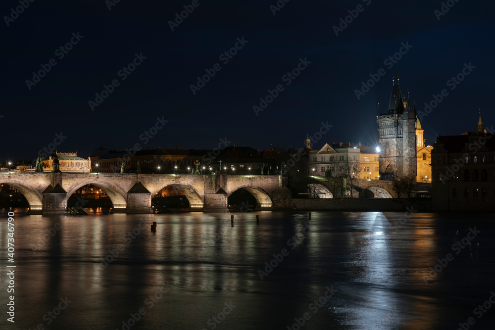 Fototapeta premium .panoramic view of Charles Bridge and illuminated street lights and the surrounding old architecture in the center of Prague in the Czech Republic at night