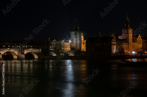 .panoramic view of Charles Bridge and illuminated street lights and the surrounding old architecture in the center of Prague in the Czech Republic at night