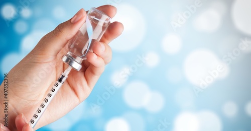 Human hand with injection syringe and vaccine