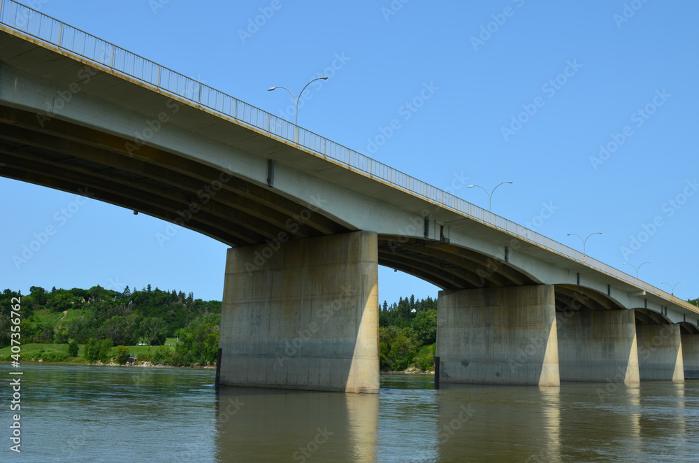 A long and wide cement manmade bridge that hovers over a beautiful river scenery, connecting each part of the city into one, from the suburbs to downtown to the parks. 