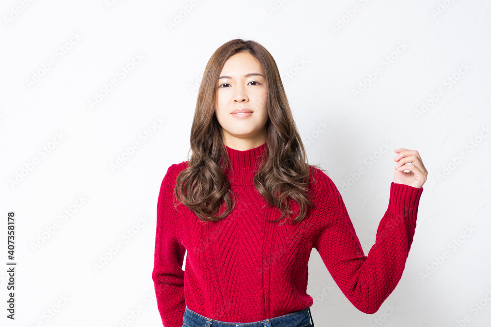 白い壁の前に立って、ポーズをとる若い女性 白い壁の前に立って、ポーズをとる若い女性