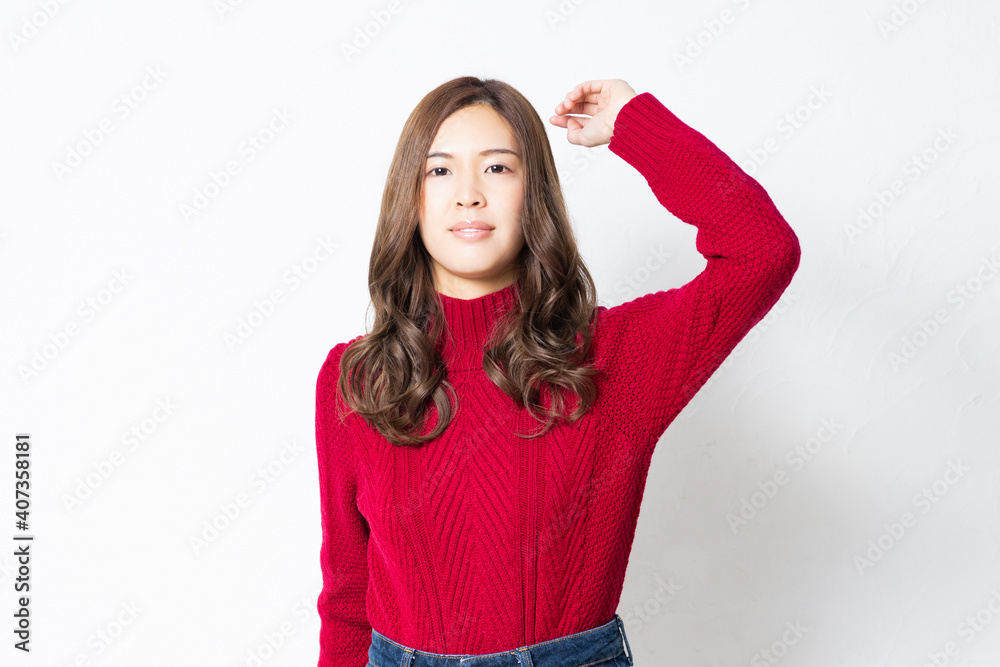 白い壁の前に立って、ポーズをとる若い女性 白い壁の前に立って、ポーズをとる若い女性