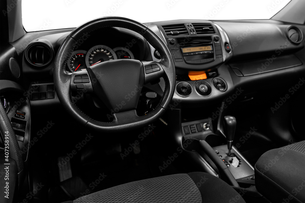 Luxurious car interior - steering wheel, shift lever and dashboard on white isolated background.