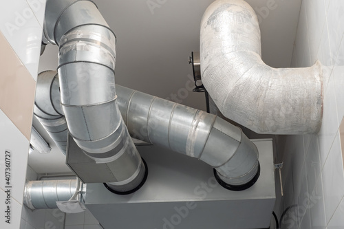 Pipes from ventilation systems or refrigeration equipment. Metal pipes under ceiling. Concept - planning ventilation networks. Installation of air conditioning systems. Indoor air distribution pipes photo