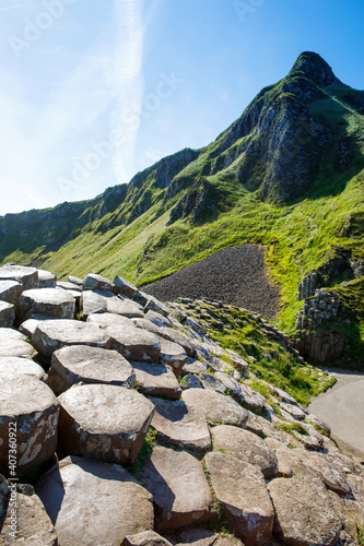 Landscape of Giant's Causeway trail with a blue sky in summer in Northern Ireland, County Antrim. UNESCO heritage. It is an area of basalt columns, the result of an ancient volcanic fissure eruption