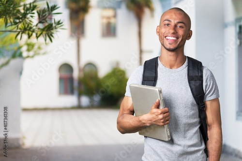 Smiling young college student with laptop