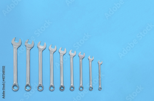 Set of wrenches different size on blue background with copy space  text place. Banner with instruments kit for repair car. Business card for tools shop. Close up. Size line. Flat lay. Layout. Mockup