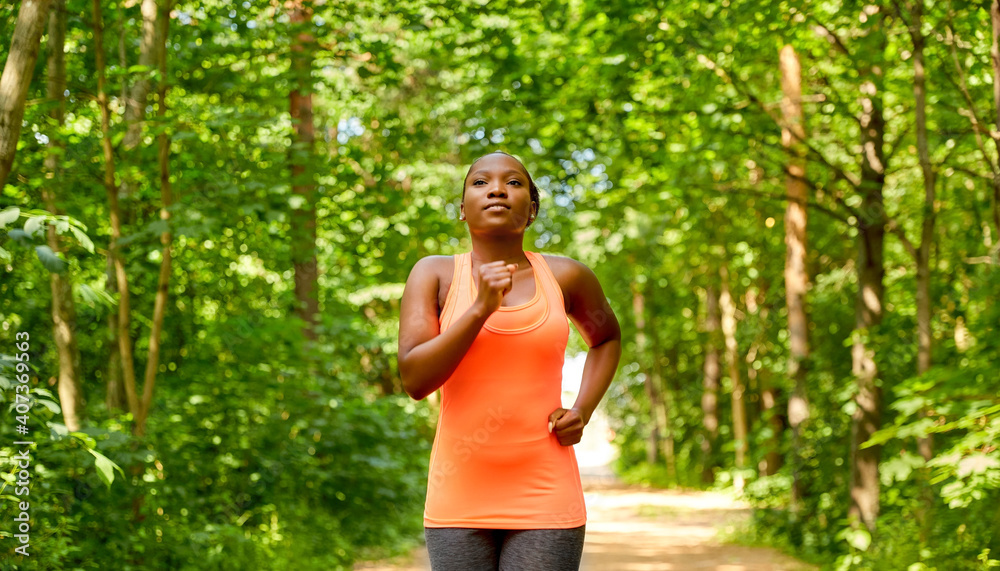 fitness, sport and healthy lifestyle concept - young african american woman running in forest fitness, sport and healthy lifestyle concept - young african american woman running in forest