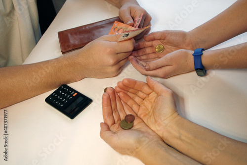 Men s hands distribute coins close-up on white background.Hands reaches out for help. The concept family budget.