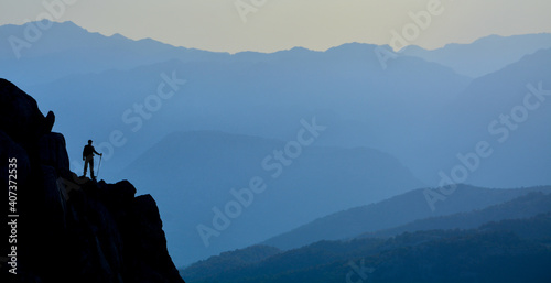 mountaineer watching the mountains at the top of the high rock