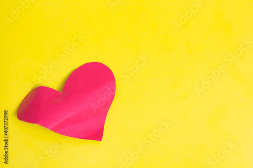 DIY red heart made of paper. As a gift for Valentine's Day. Close-up. Colored background. Place for an inscription.