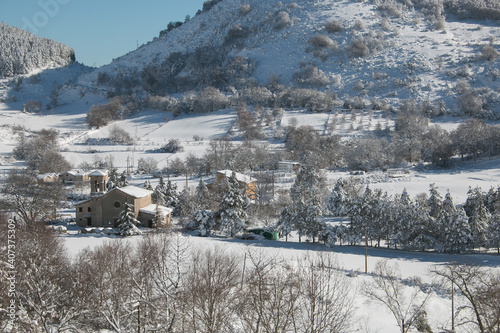 Panoramic view of little mountain village covered by snow in Umbria photo