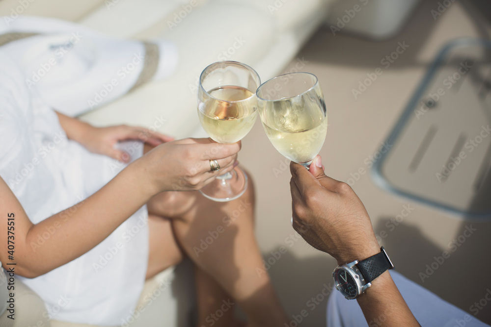 Couple is celebrating their honeymoon on a yacht. honeymooners clink glasses wLovers celebrate their honeymoon on a yacht. Newly married couple clink glasses with champagneith champagne Couple is celebrating their honeymoon on a yacht. honeymooners clink glasses wLovers celebrate their honeymoon on a yacht. Newly married couple clink glasses with champagneith champagne