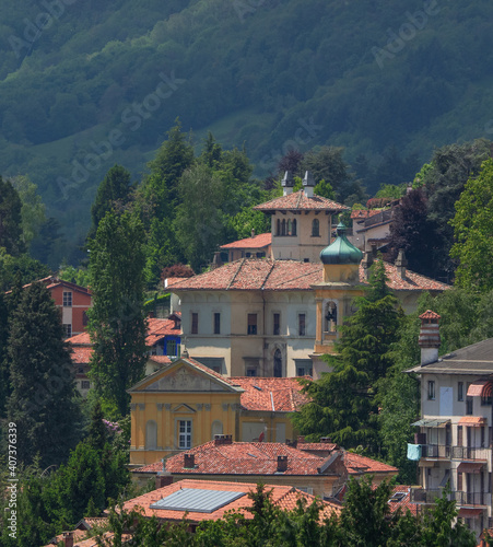 Aerial view of a cozy mountain village immersed in the greenery of the Biellese alps. Piedmont, Italy.