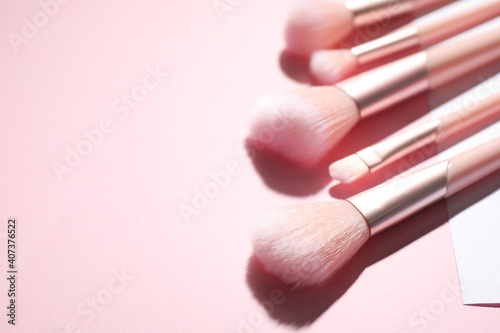 Set of professional makeup brushes on color background. Space for text