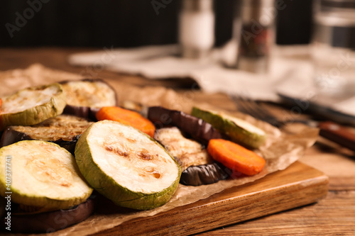 Delicious grilled vegetables served on wooden table, closeup