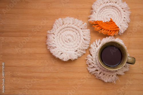 Macrame handmade Hobby.Top View black hot coffee in a cup on white macrame coasters