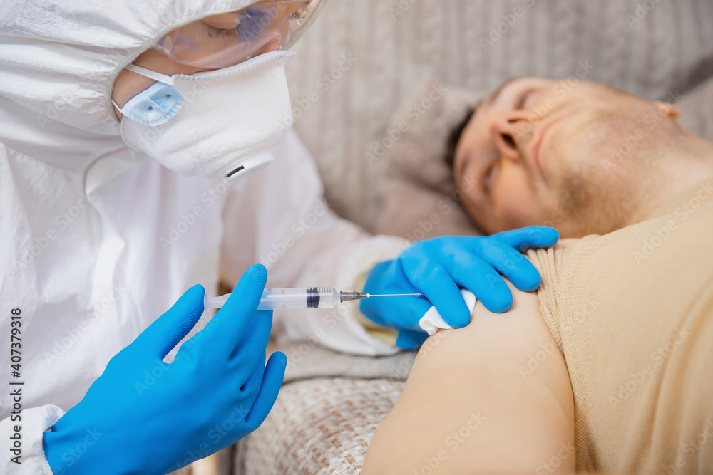 Close-up vaccination inoculation of patient in shoulder, syringe with covid vaccine flu is injected into sick man