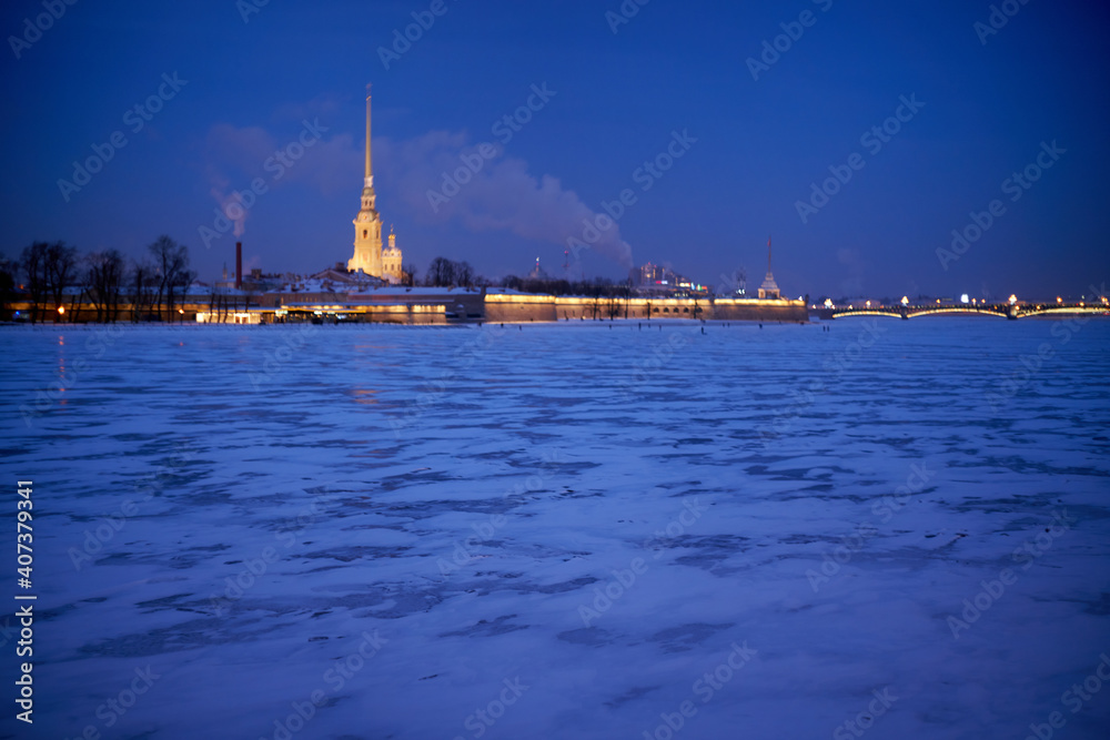 Fototapeta premium Evening view of illuminated Peter and Paul Fortress on a winter evening. Winter in St. Petersburg, Russia.
