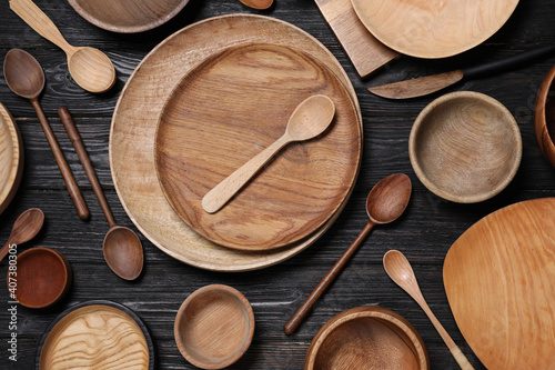 Flat lay composition with wooden dishware on black table