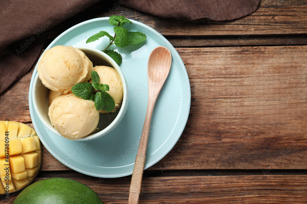 Delicious mango ice cream served on wooden table, flat lay. Space for text - obrazy, fototapety, plakaty 