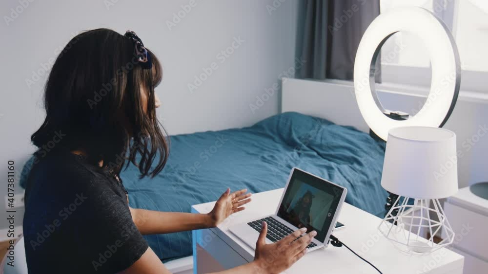 Young woman recording online lesson in her bedroom illuminated buy ring light. High quality 4k footage