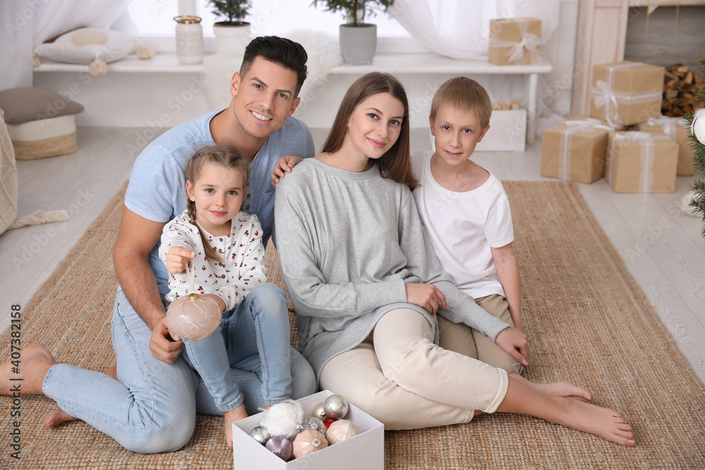 Happy family with box of Christmas ornaments at home Happy family with box of Christmas ornaments at home