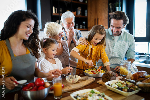 Cheerful family spending good time together while cooking in kitchen