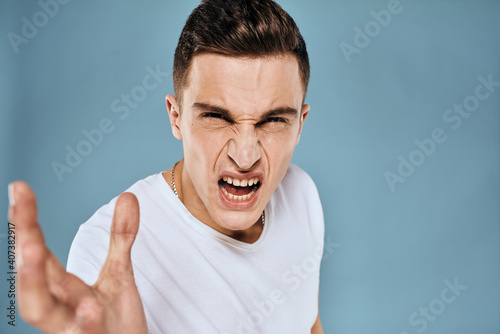 emotional displeased man cropped view white t-shirt blue background