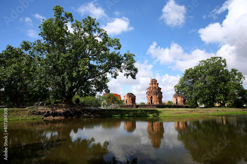 Prasat Sikhoraphum or Castle Rock temple in Surin of Thailand, reflection in pond water with beautiful blue sky and clouds background.  photo