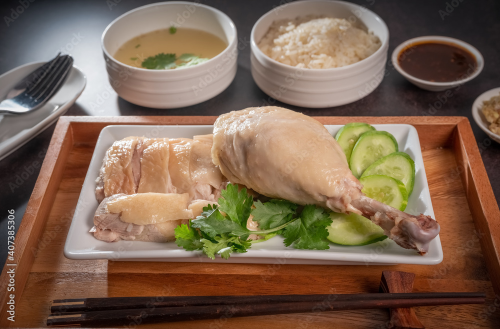 Steamed chicken and rice with spicy sauces and chicken soup, Hainanese chicken rice on a black table background, Steamed chicken and rice with spicy sauces and chicken soup, Hainanese chicken rice on a black table background,