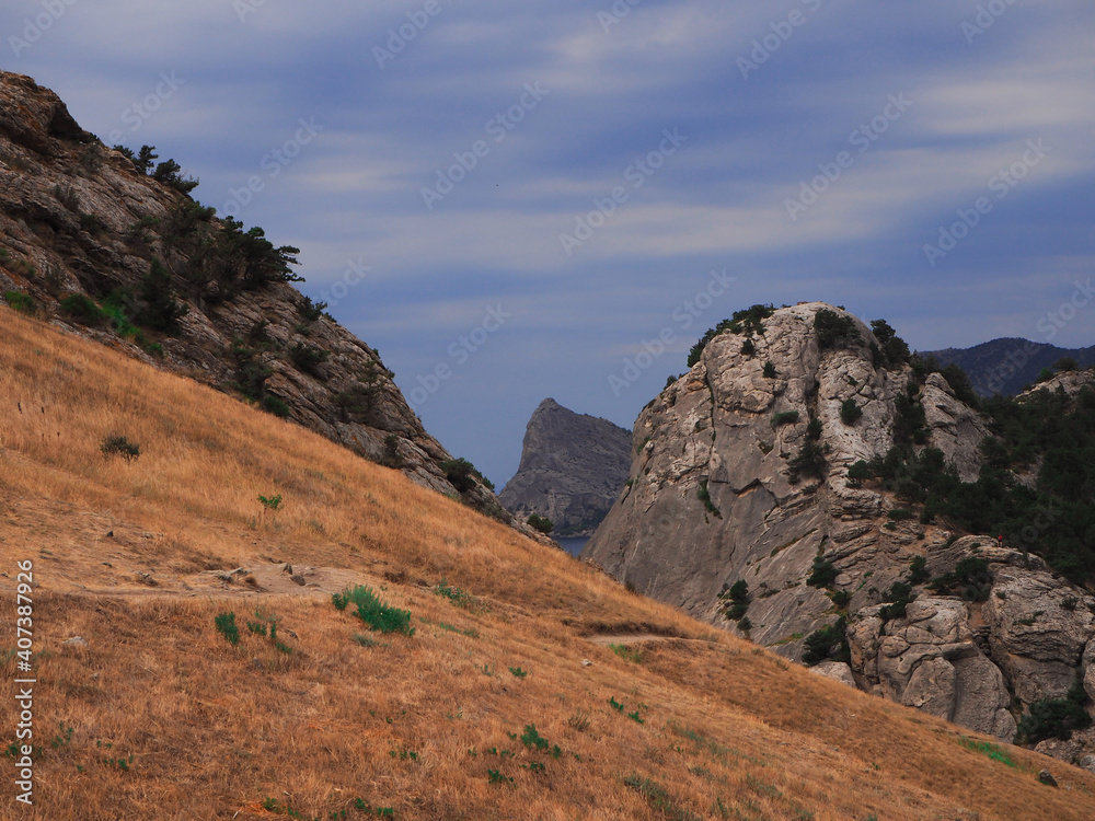 Fototapeta premium Landscape of stone mountains on a summer day. Variegated bright colors: blue, sandy, green. Stones in their natural environment.