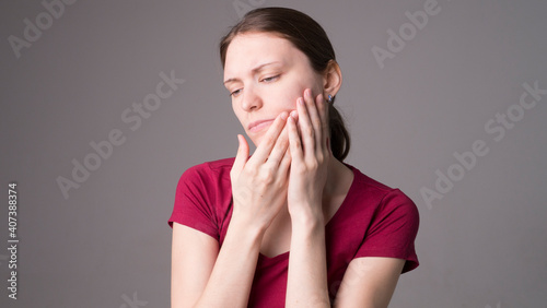 A tired woman feels pain in her teeth