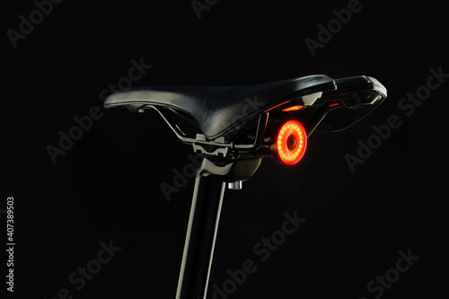 Close-up of illuminated bicycle tail light on black background