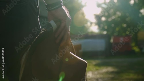 close up of a cowboy hat and a man walking at sunset