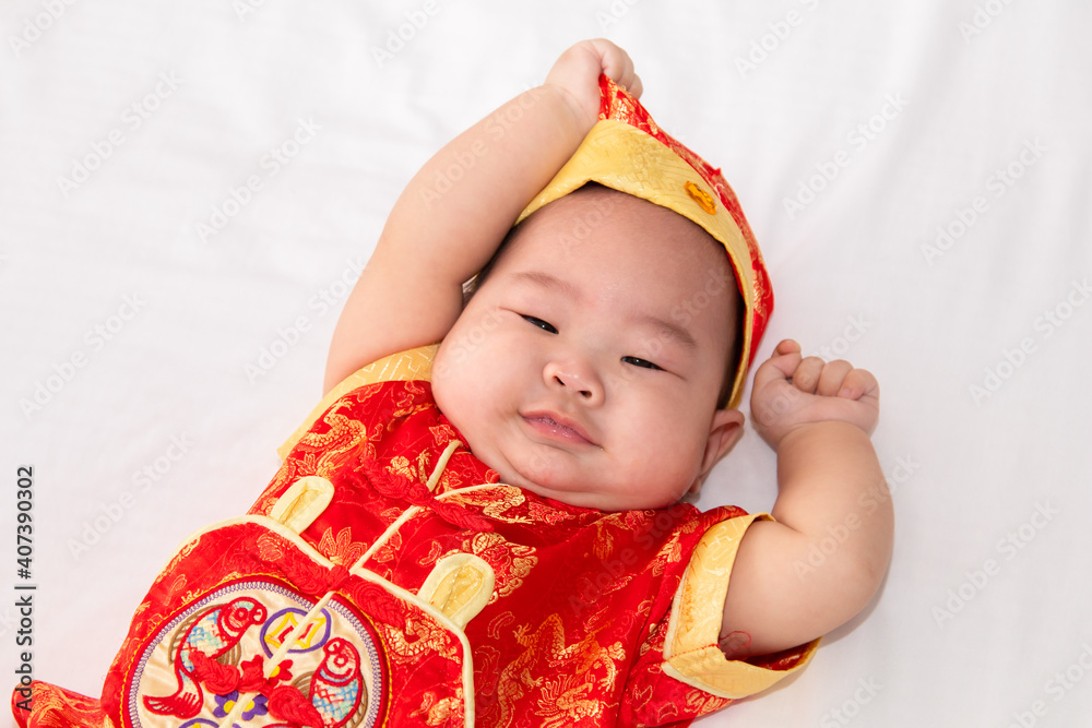 Adorable Asian Chinese healthy baby lie down on bed looking for mom feeding, happy cute boy infant playing alone feeling happy, Chinese New Year wealthy prosperous Traditional Festival concept Adorable Asian Chinese healthy baby lie down on bed looking for mom feeding, happy cute boy infant playing alone feeling happy, Chinese New Year wealthy prosperous Traditional Festival concept