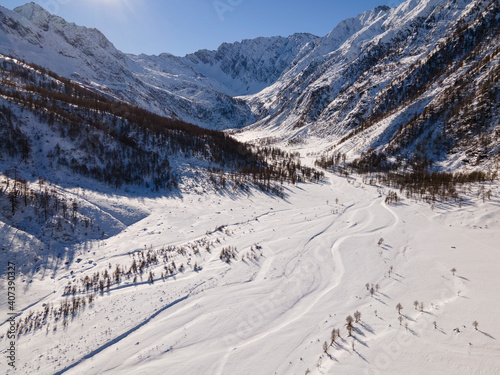 Daylight drone shot in mountain landscape with snow. Alps, Italy. Aerial view. 