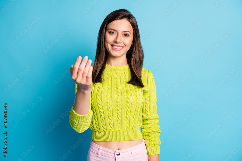 Photo of young beautiful woman show gesture hand invite welcome wear green jumper isolated over blue color background