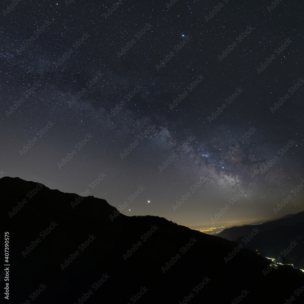 night milkyway long exposure composition with Jupiter and Saturn just above the mountains