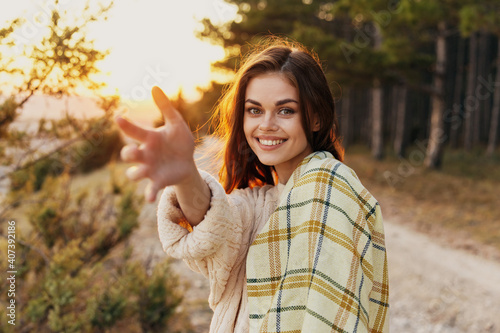 happy woman smiling in nature and stretches her hand forward sunset in the background