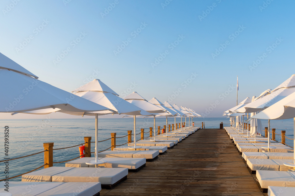 Fototapeta premium Pier with sunbeds and umbrellas