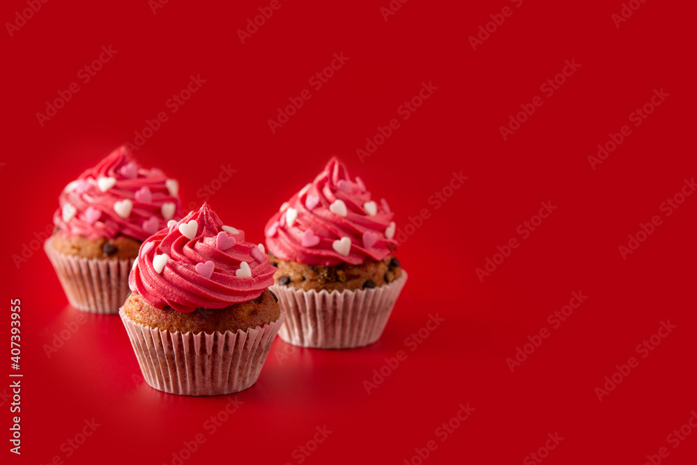 Cupcakes decorated with sugar hearts for Valentine's Day on red background.Copy space Cupcakes decorated with sugar hearts for Valentine's Day on red background.Copy space
