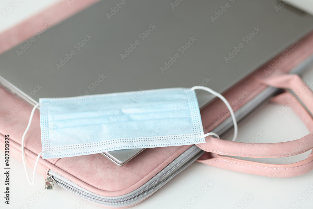 Protective medical mask lying on laptop closeup Protective medical mask lying on laptop closeup