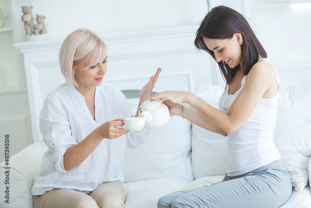Mother and daughter drinking tea indoors